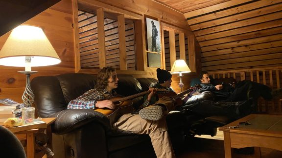 Poplar Stream Hut Lounge with a two people playing guitar.