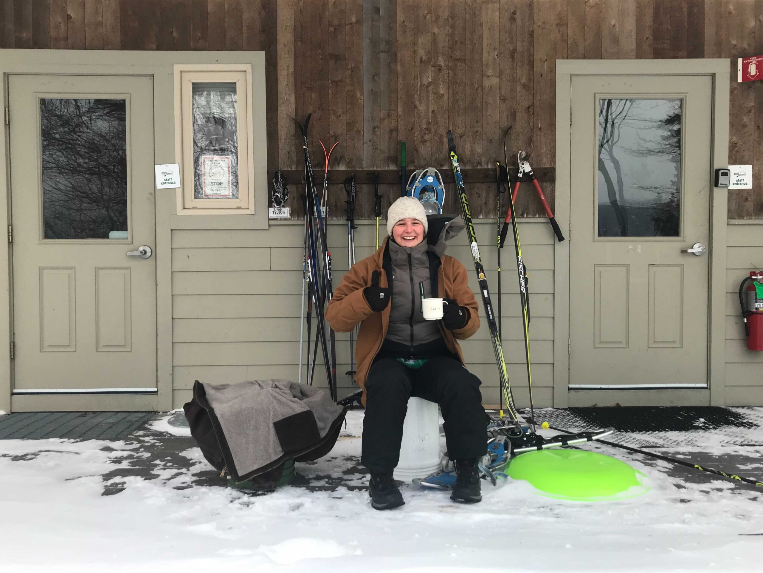 Hut staff in front of bunkhouse in winter.