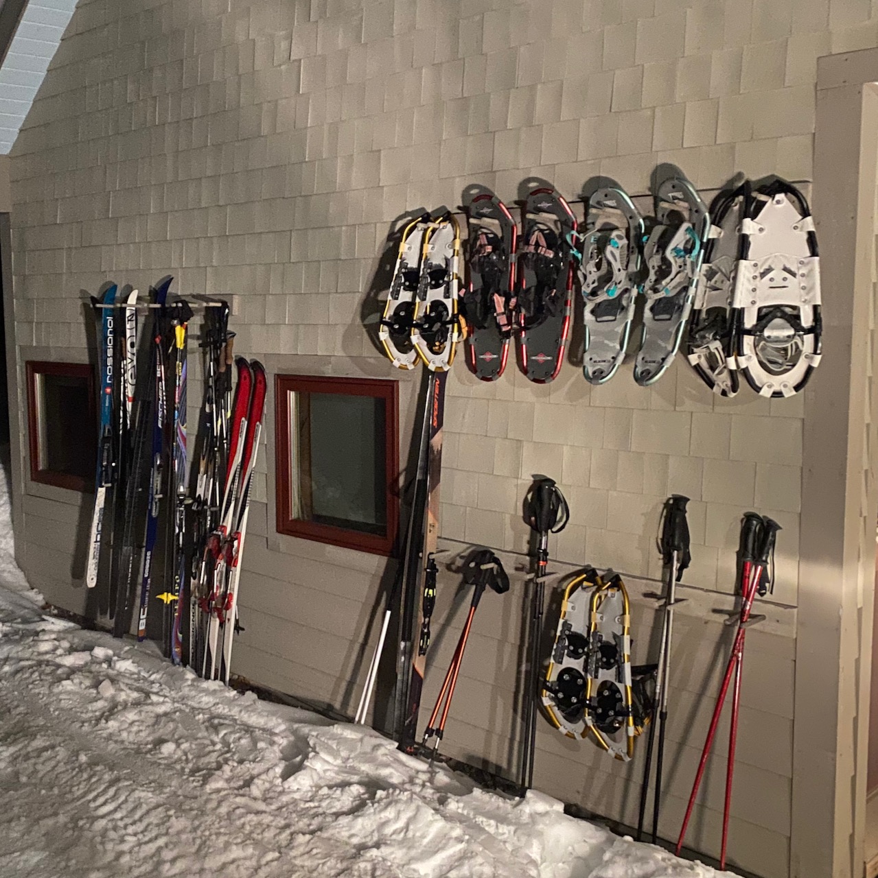 Poplar Hut outside at night with snowshoes and cross country skis.