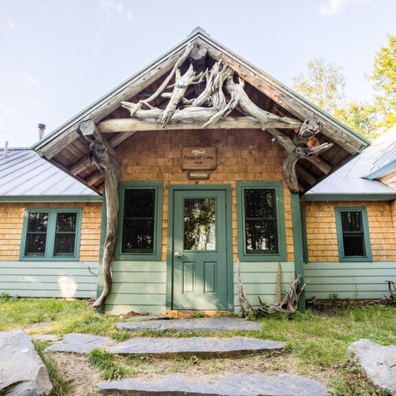 Front exterior of Flagstaff Lake Hut during summer.