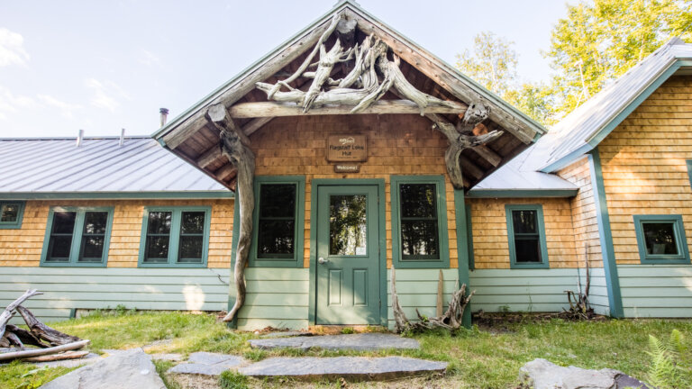 Front exterior of Flagstaff Lake Hut during summer.