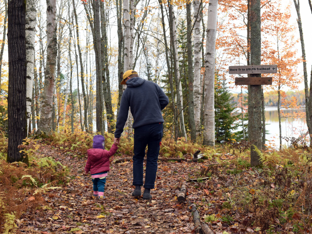 Family walking outside Flagstaff Lake Hut in fall