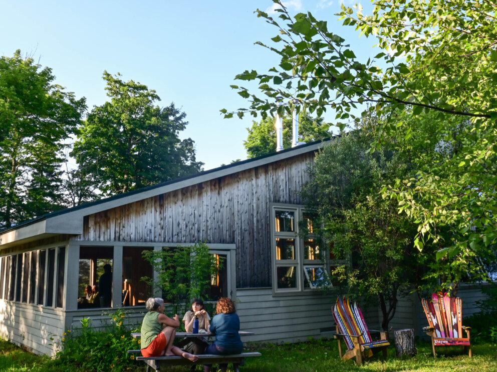 Summer guests relax outside of Stratton Brook Hut.
