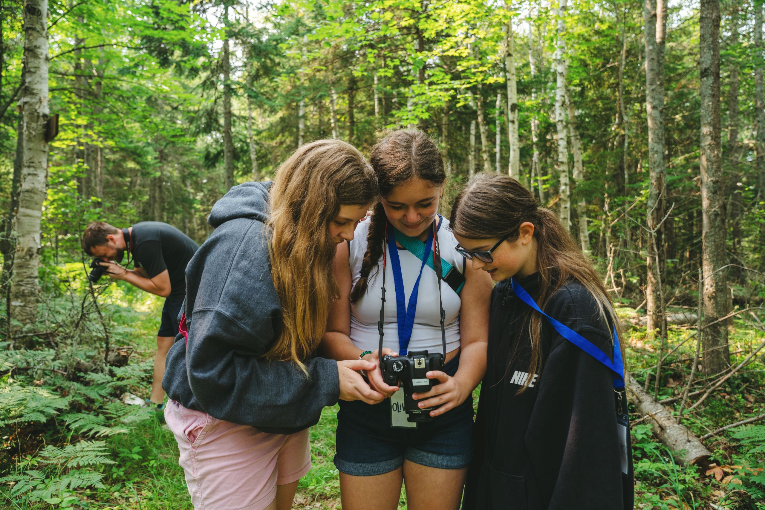 Students looking at their camera on the trail