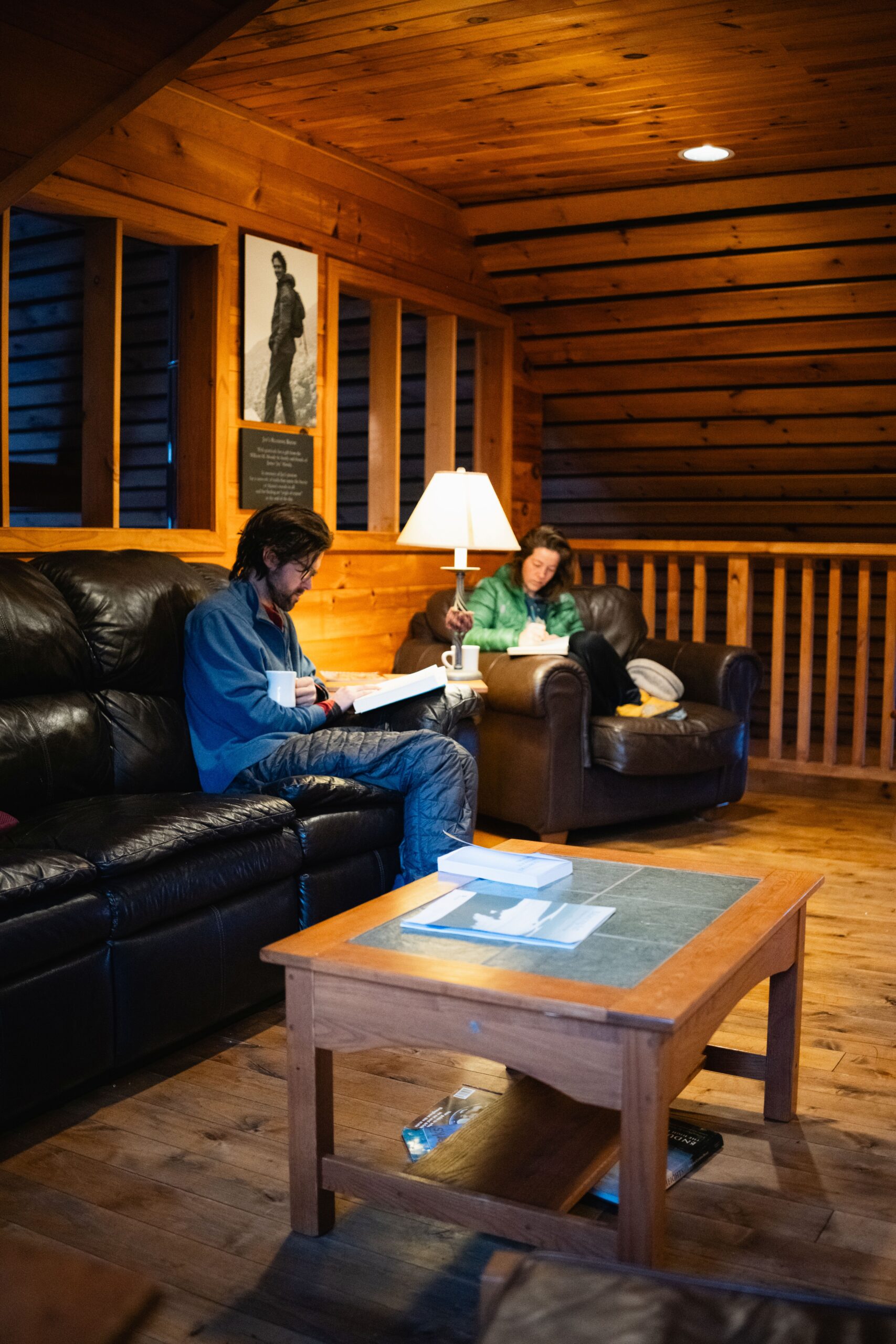 Guests reading in the library at Poplar Stream Hut.
