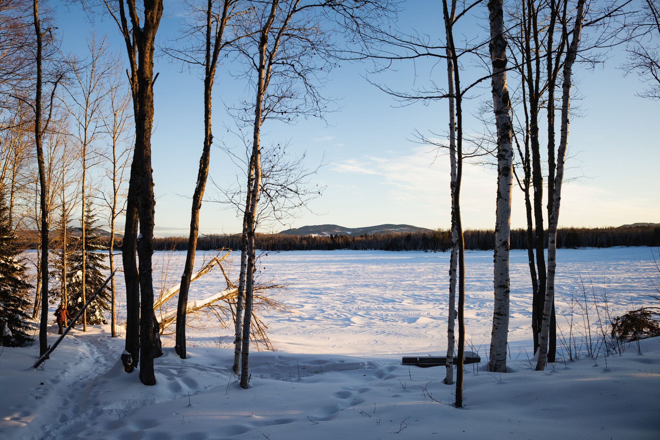 View from front of Flagstaff Lake Hut, looking out on snowy and frozen Flagstaff Lake and mountains.