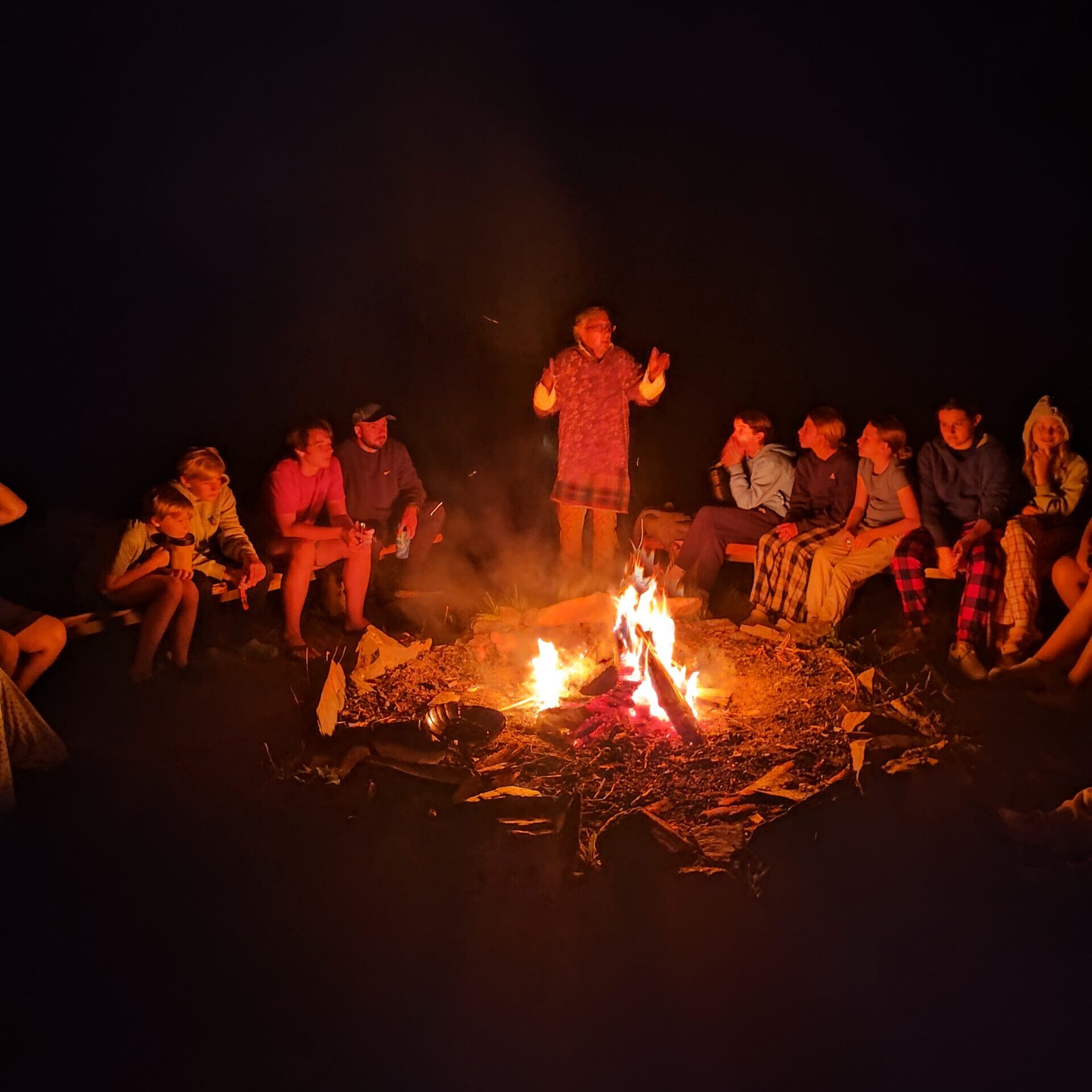 Group of school students around a campfire