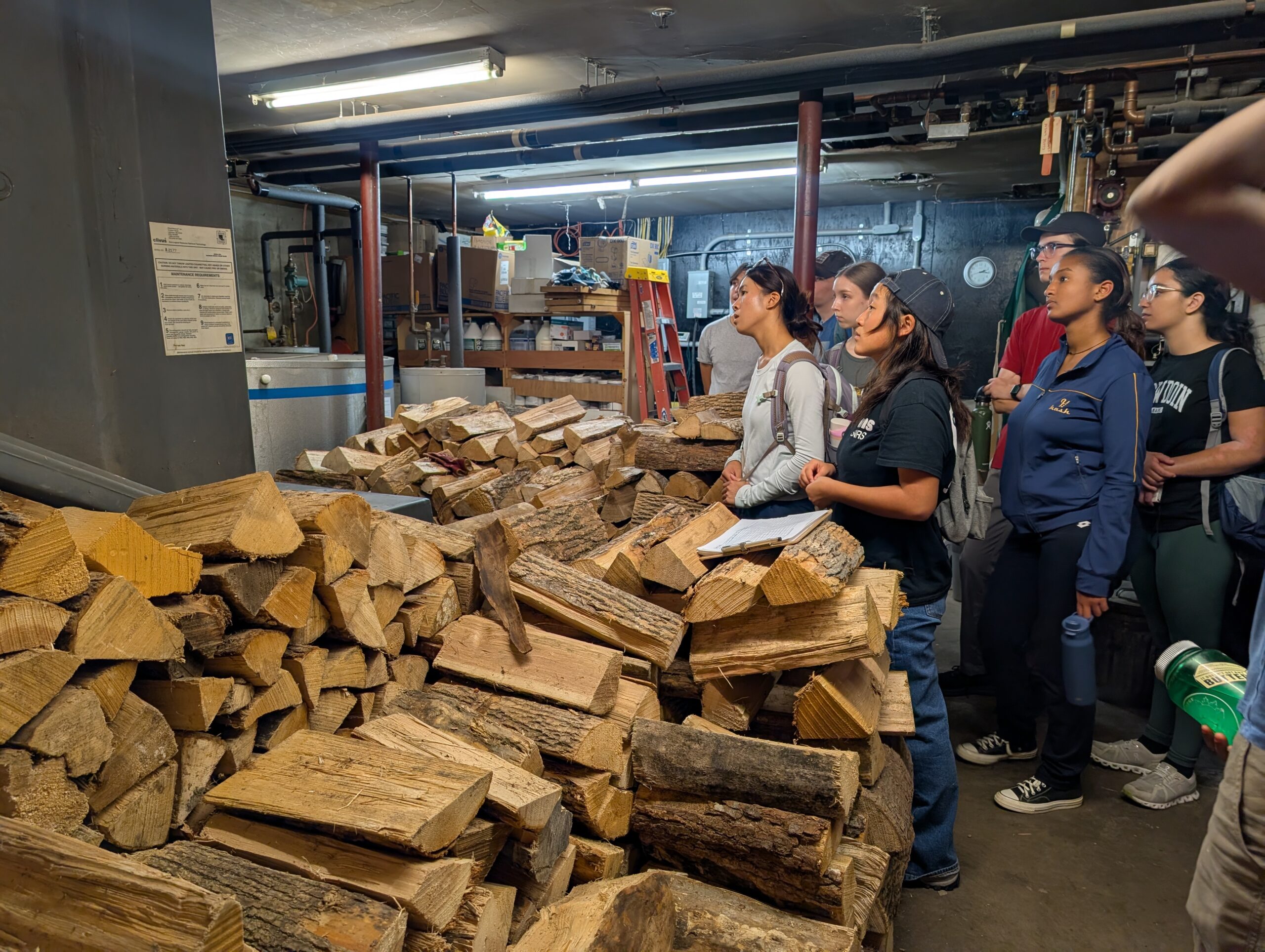Bowdoin College volunteer wood stacking.