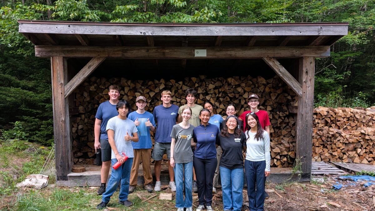 Bowdoin College volunteer wood stacking.