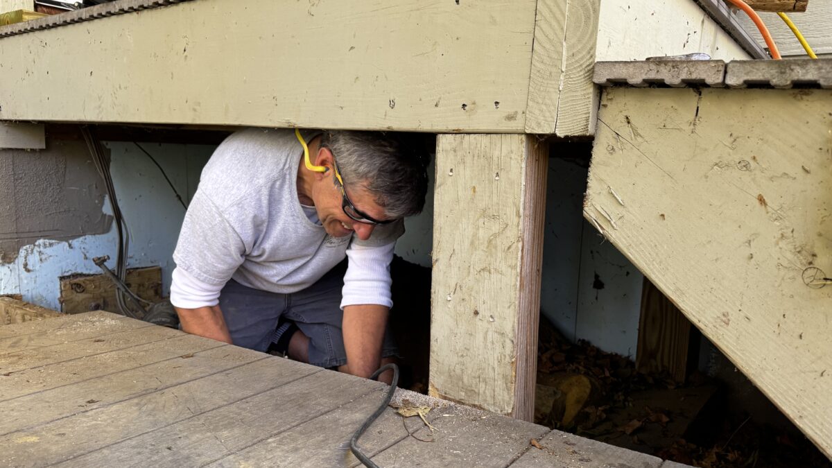 Board President Fred Prescott repairs the deck at Stratton Brook Hut.