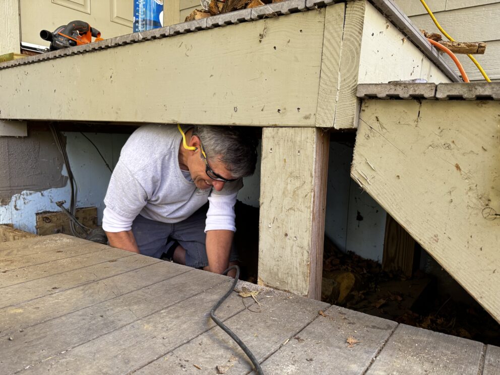 Board President Fred Prescott repairs the deck at Stratton Brook Hut.